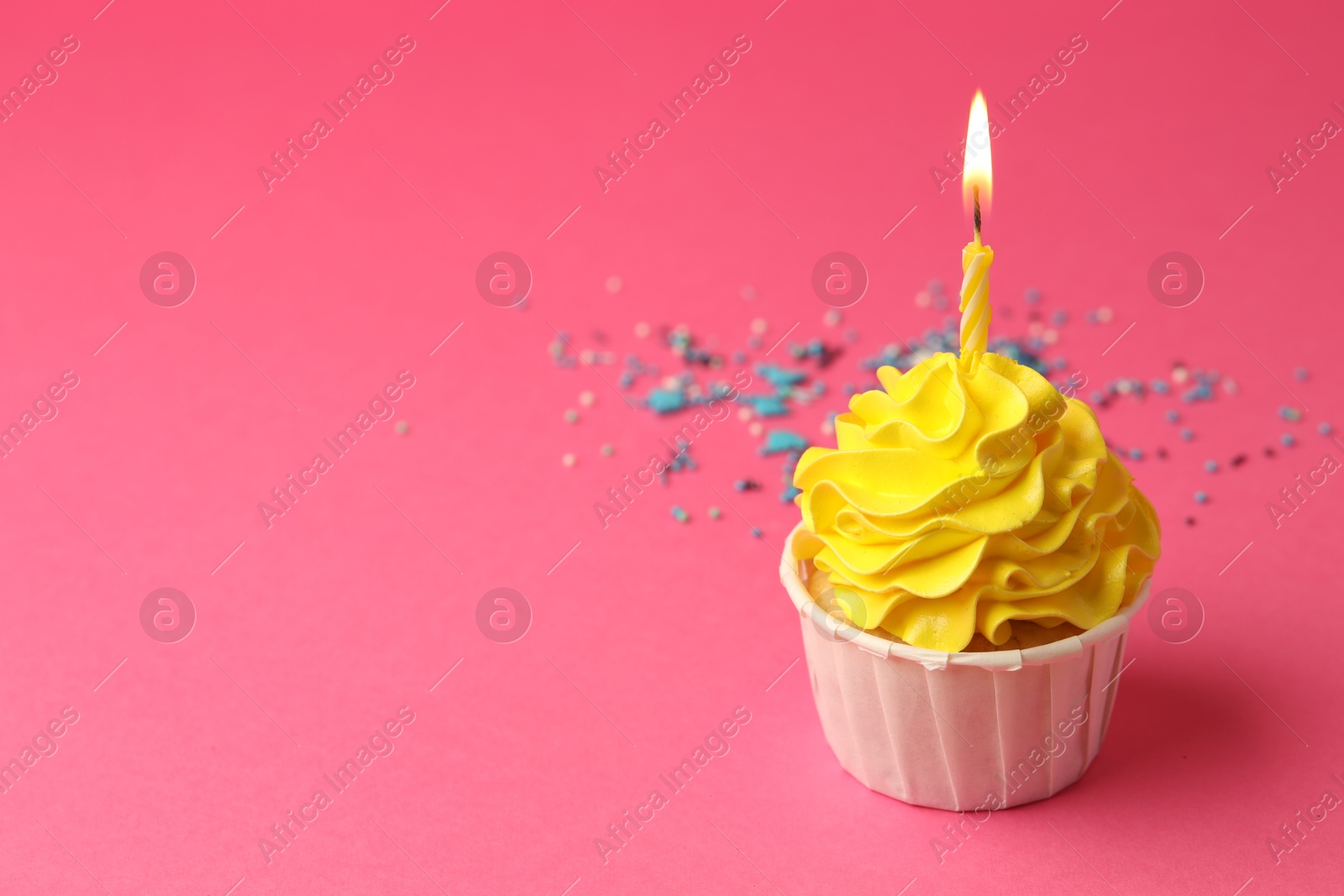 Photo of Tasty cupcake with burning candle on pink background, space for text