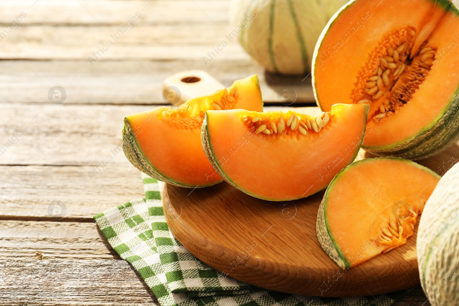 Photo of Tasty ripe Cantaloupe melons on wooden table, closeup