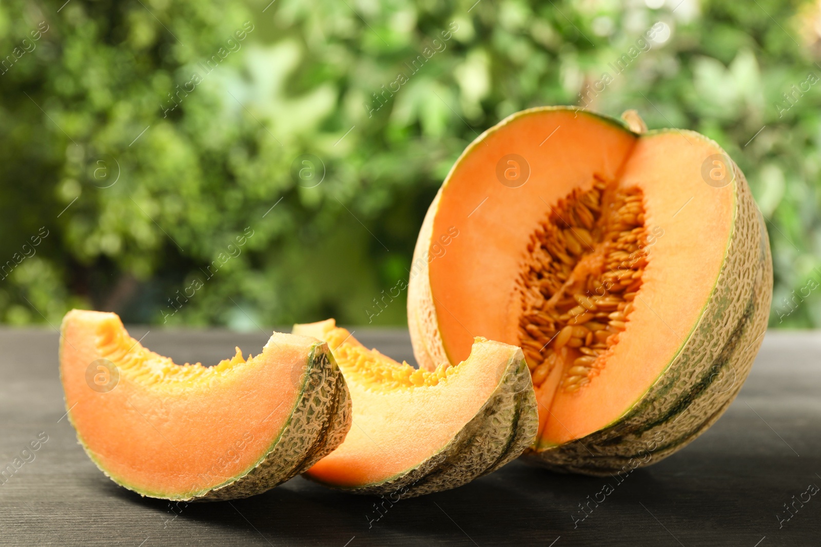 Photo of Fresh ripe Cantaloupe melon on dark wooden table, closeup