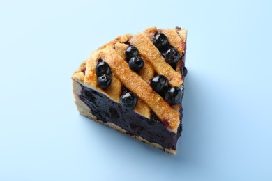 Photo of Slice of homemade blueberry pie on light blue background