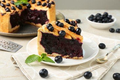 Photo of Slice of delicious homemade blueberry pie served on light table, closeup