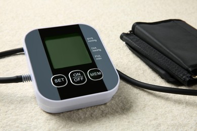 Blood pressure measuring device on light textured background, closeup