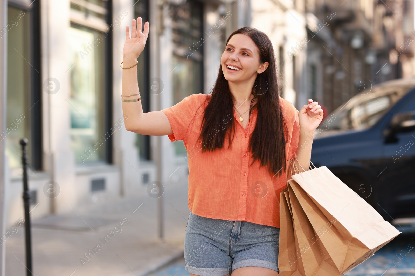 Photo of Happy woman with many shopping bags outdoors