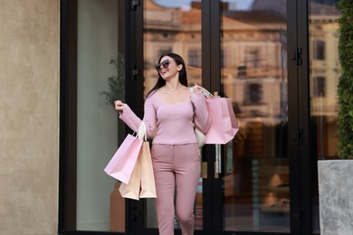 Happy woman with colorful shopping bags outdoors