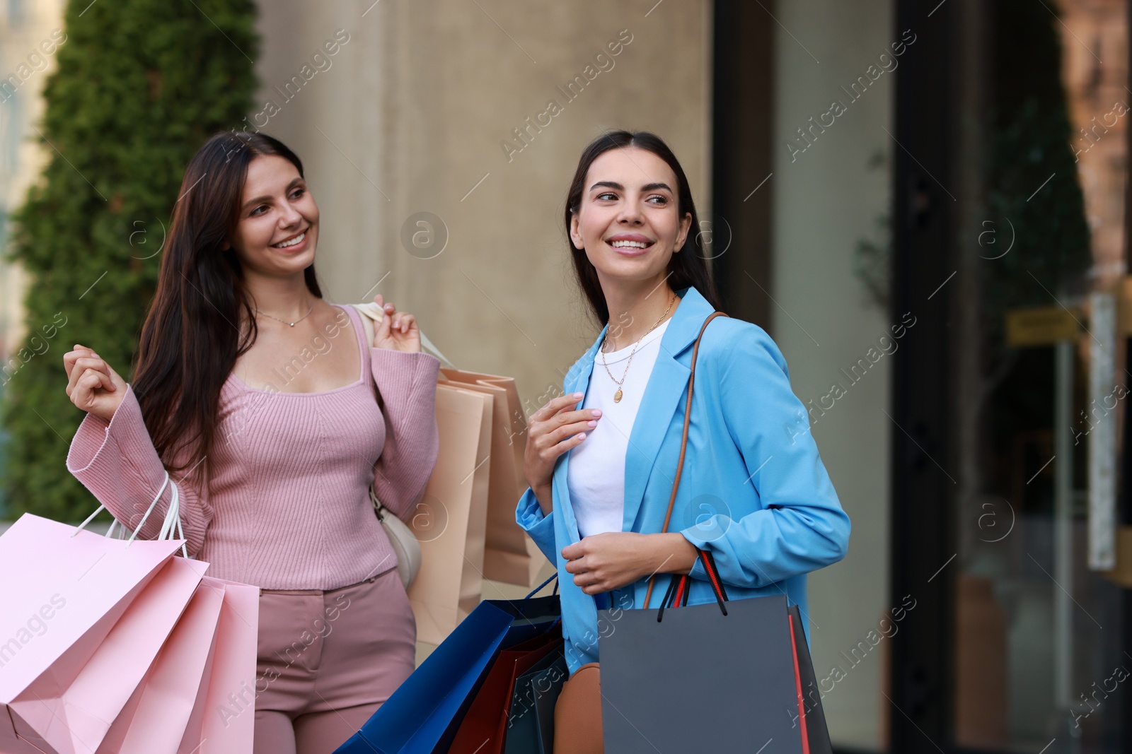 Photo of Happy women with colorful shopping bags outdoors