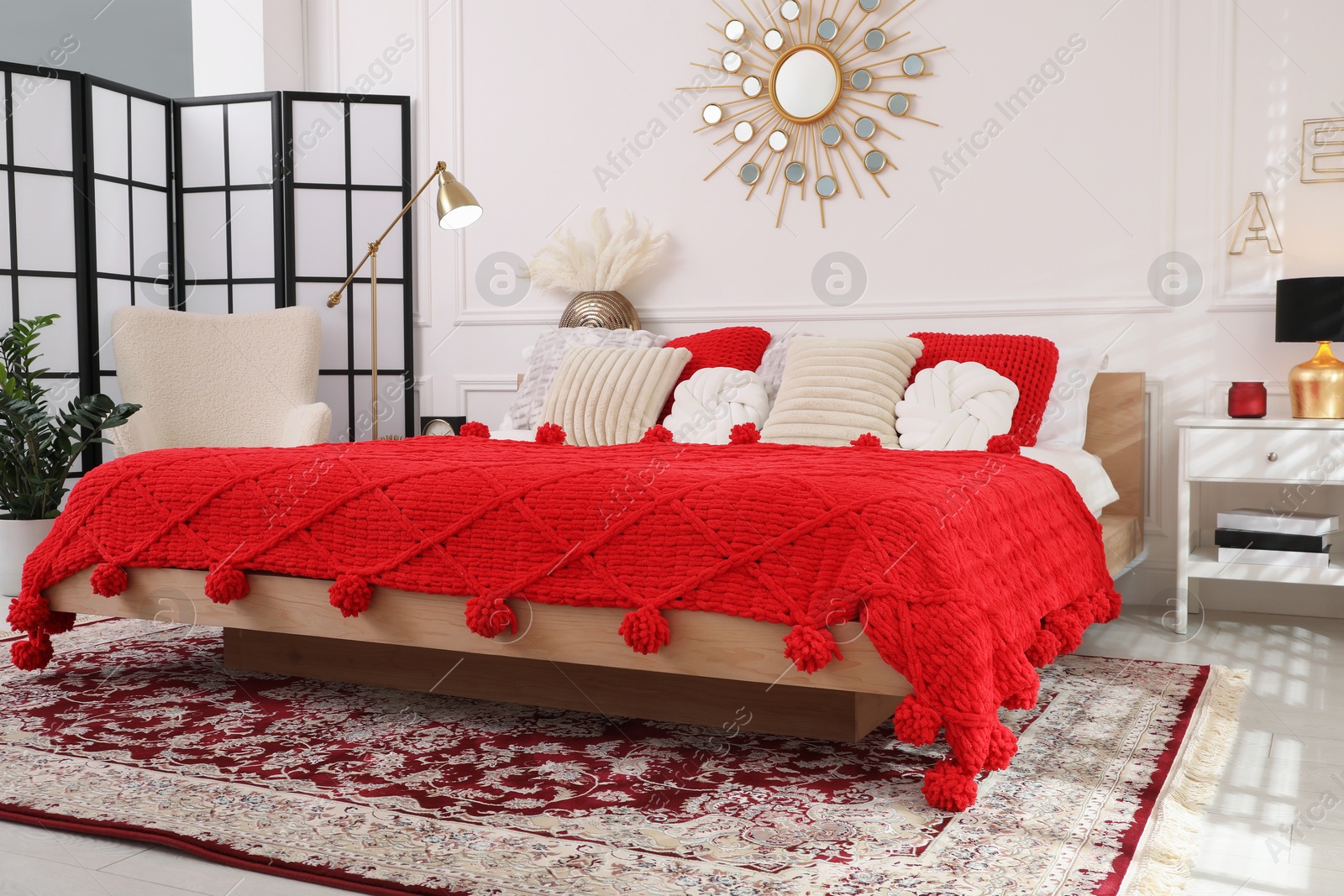 Photo of Big comfortable bed and decorative elements in room. Stylish bedroom interior