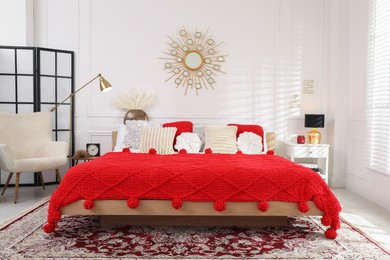 Photo of Big comfortable bed and decorative elements in room. Stylish bedroom interior