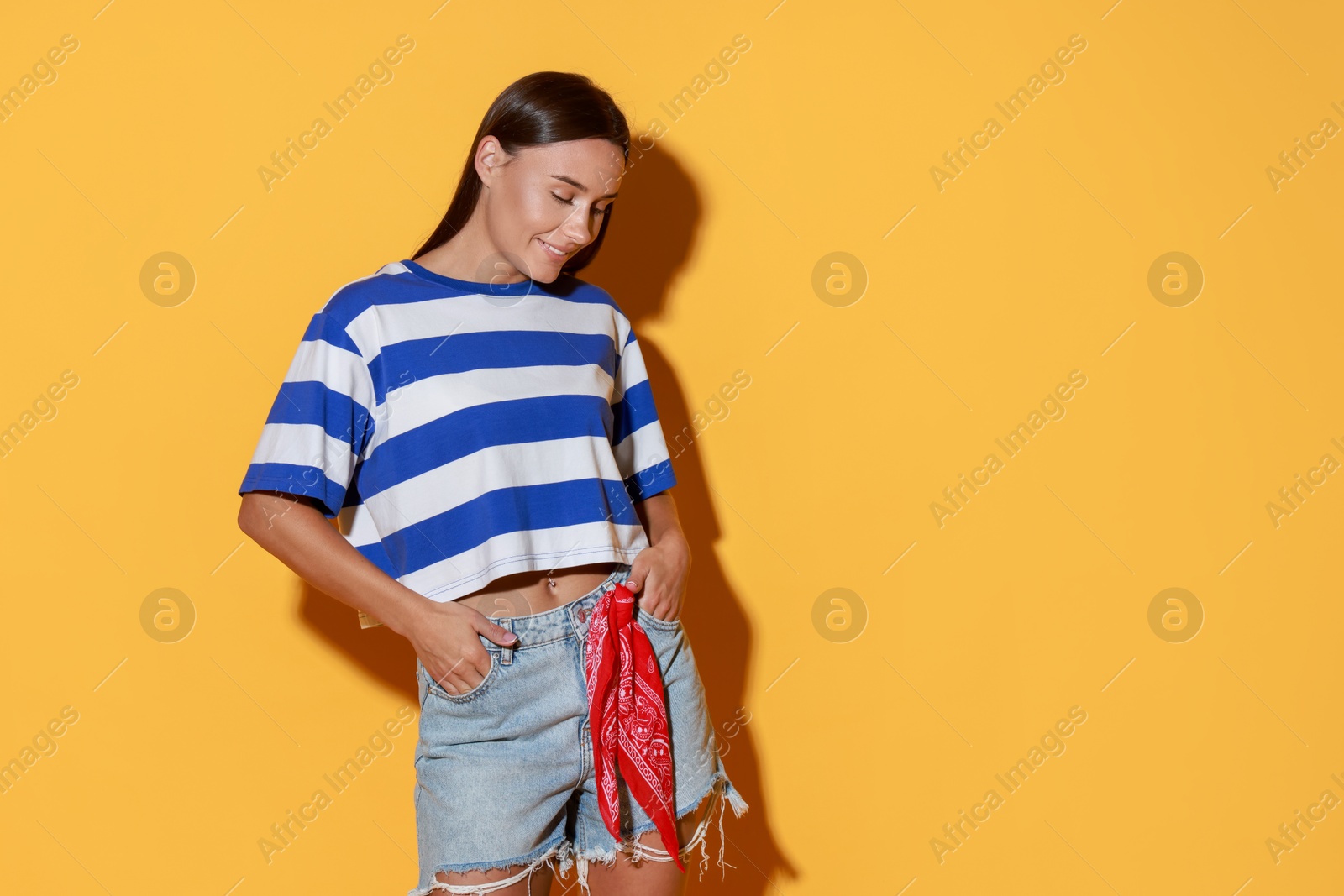 Photo of Beautiful woman wearing stylish denim shorts on yellow background