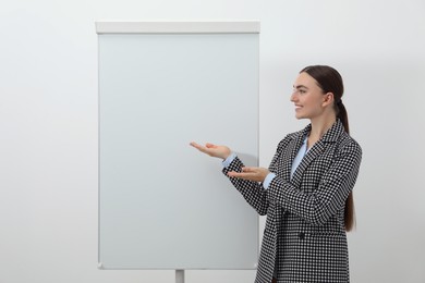 Happy woman near flip chart on white background. Mockup for design