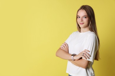 Portrait of teenage girl on yellow background, space for text