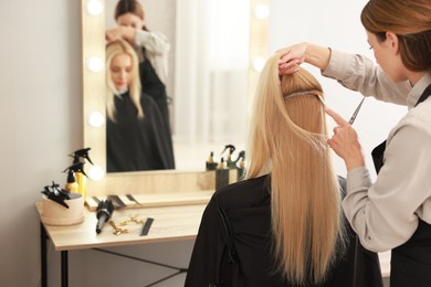 Photo of Hair cutting. Professional hairdresser working with client in salon