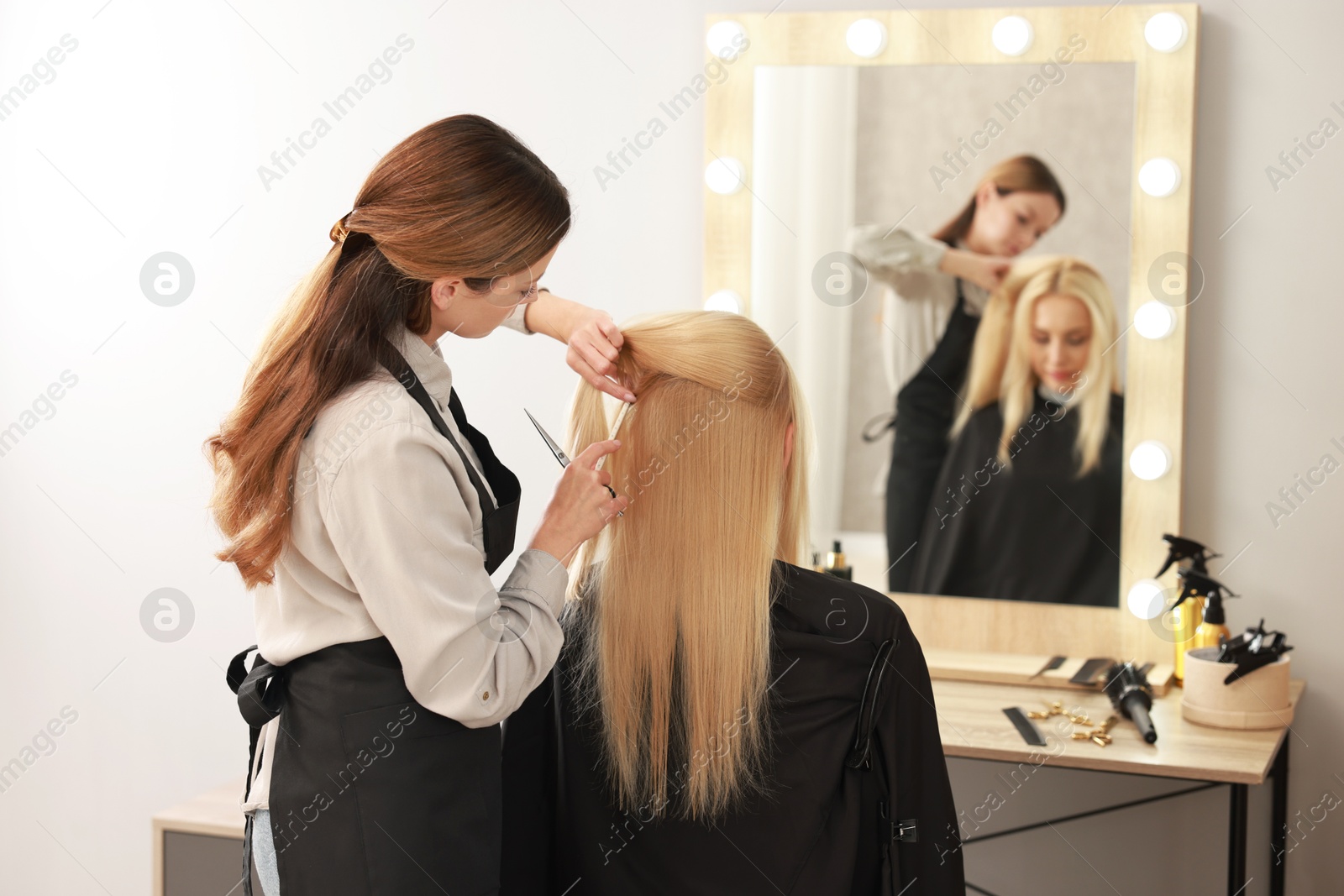 Photo of Hair cutting. Professional hairdresser working with client in salon