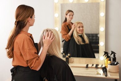 Photo of Hair cutting. Professional hairdresser working with client in salon