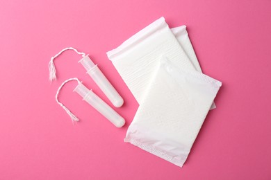 Photo of Menstrual pads and tampons on pink background, top view