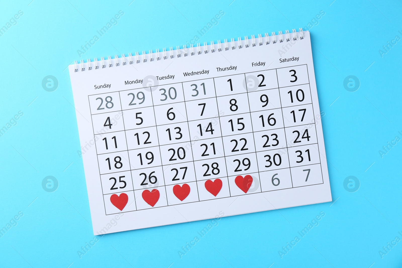 Photo of Menstruation. Calendar with marked dates on light blue background, top view