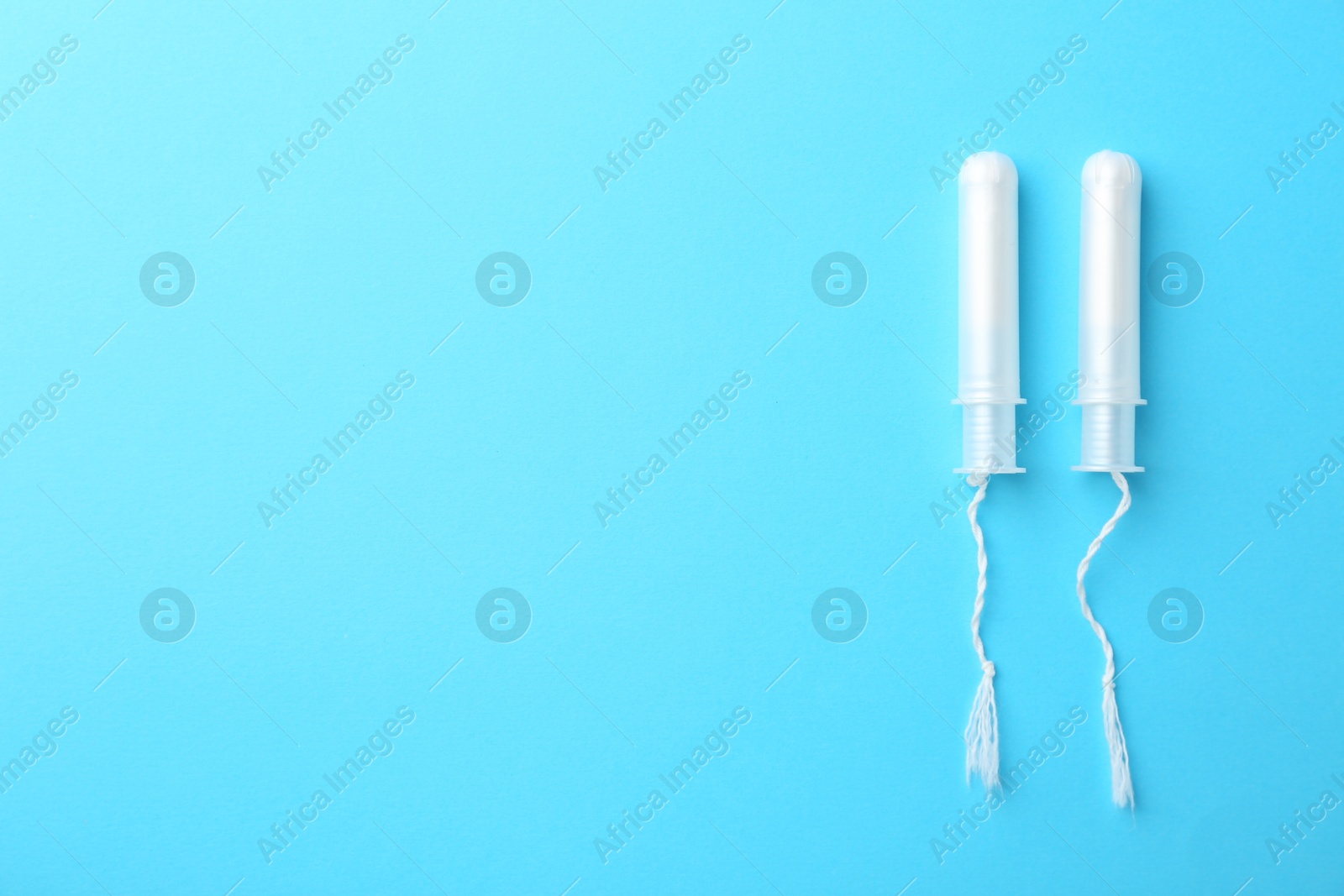 Photo of Menstruation. Tampons on light blue background, top view. Space for text