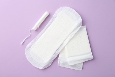 Flat lay composition with menstrual products on violet background