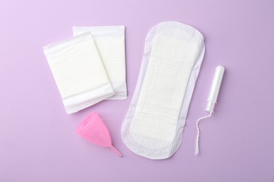 Photo of Flat lay composition with menstrual products on violet background