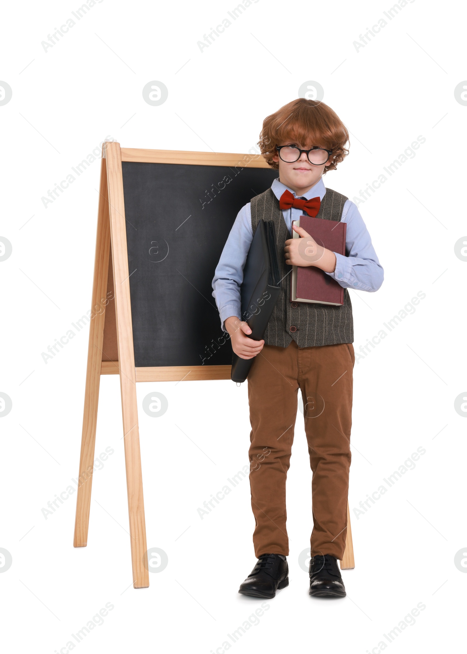 Photo of Little boy with book and folder near chalkboard on white background. Dreaming about future profession