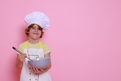 Photo of Little boy with bowl and whisk pretending to be chef on pink background, space for text. Dreaming about future profession