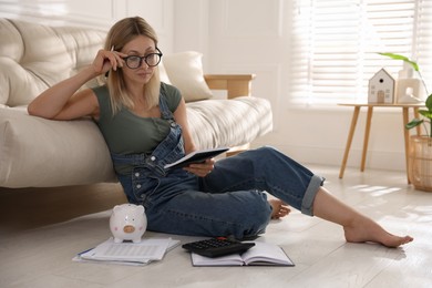 Budget planning. Woman working with accounting documents on floor indoors