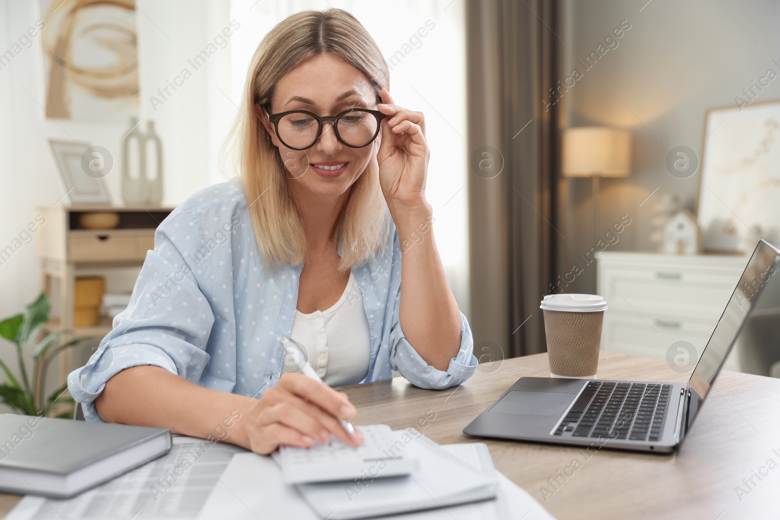 Photo of Budget planning. Woman using calculator at table indoors