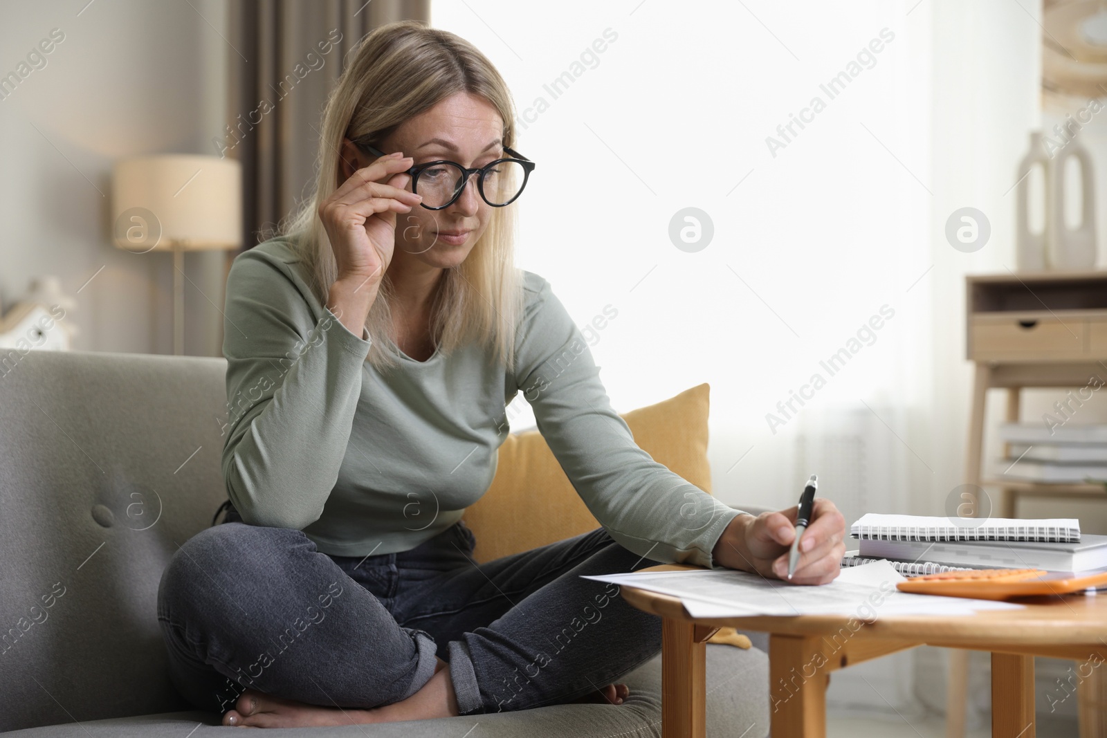 Photo of Budget planning. Woman working with accounting documents at table indoors