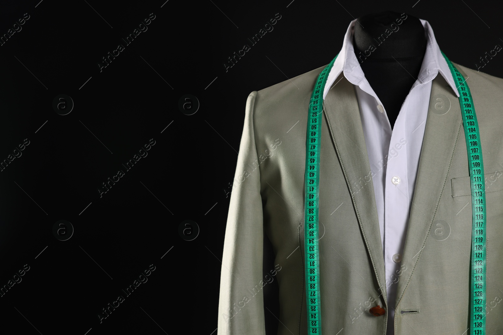 Photo of Male mannequin with jacket, white shirt and measuring tape on black background, space for text