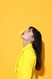 Photo of Woman with beautiful flower on yellow background