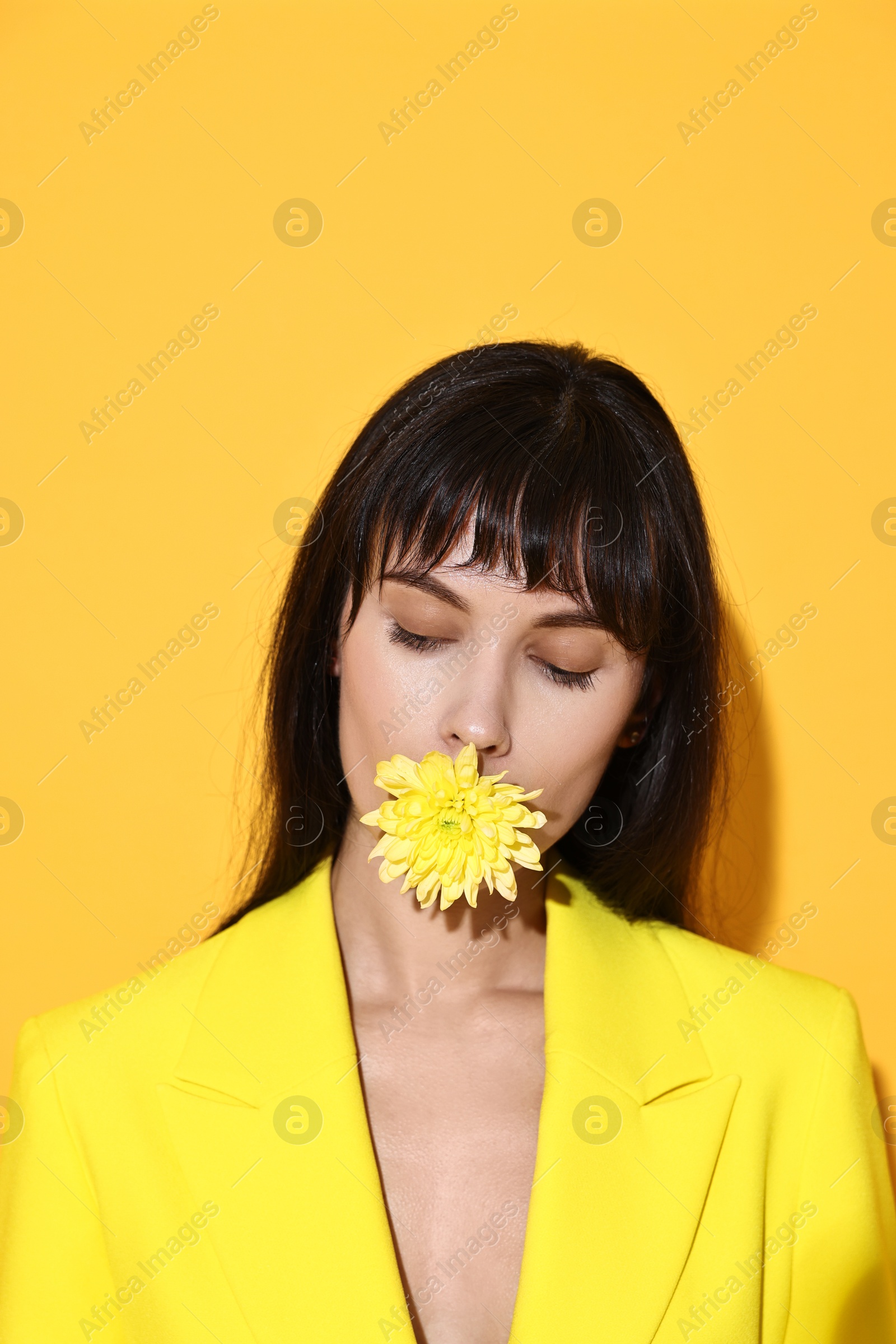 Photo of Woman with beautiful flower on yellow background