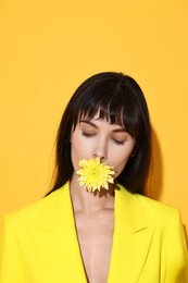 Photo of Woman with beautiful flower on yellow background