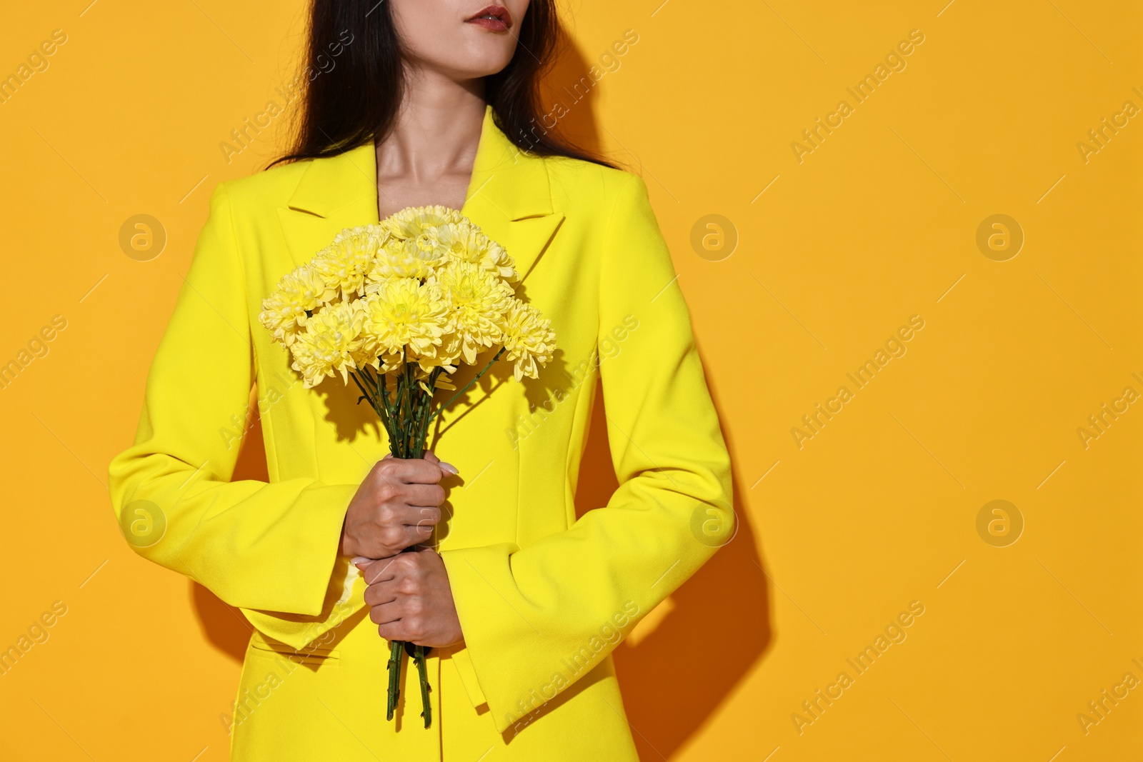 Photo of Woman with beautiful bouquet of flowers on yellow background, closeup. Space for text