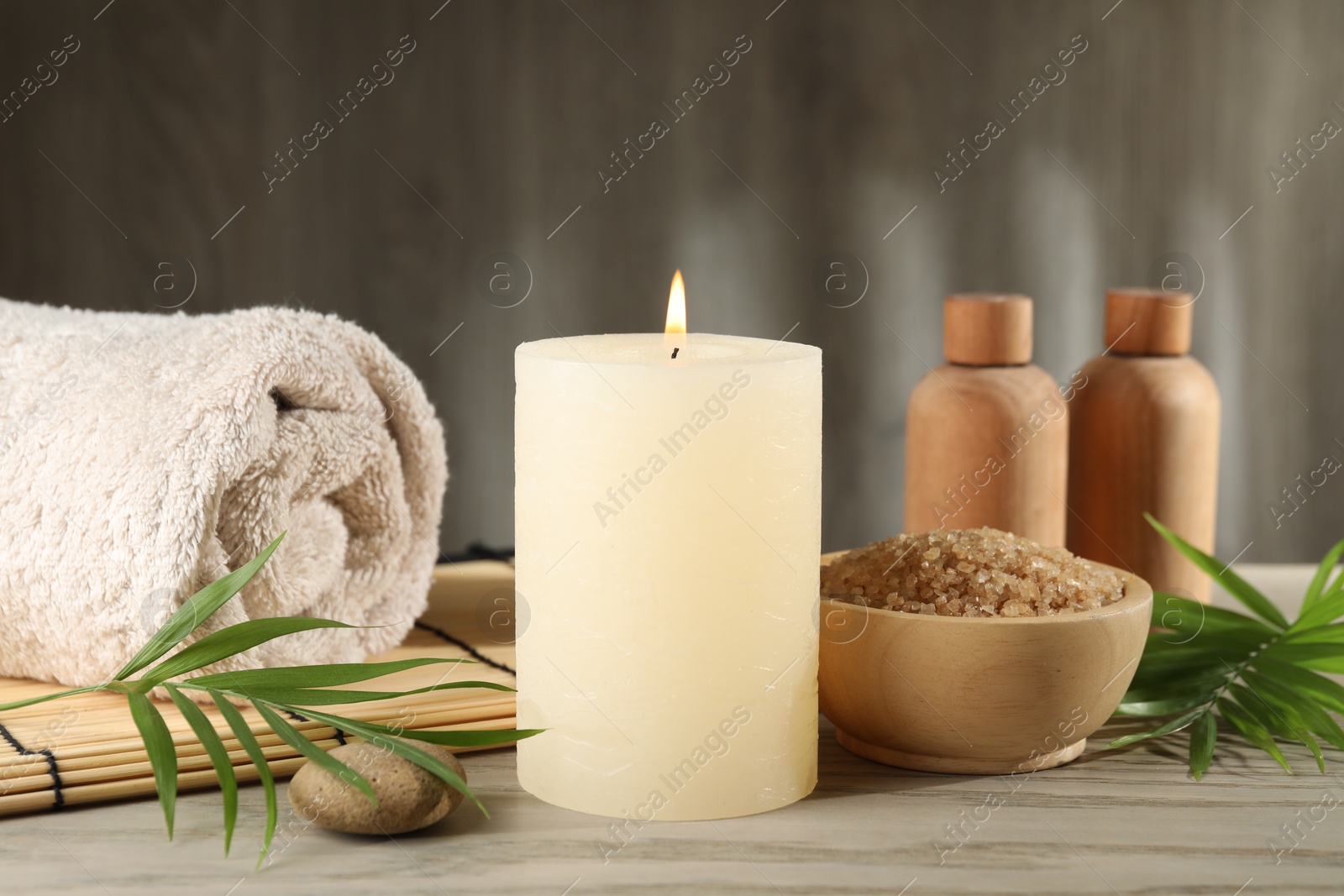 Photo of Spa composition with burning candle on wooden table