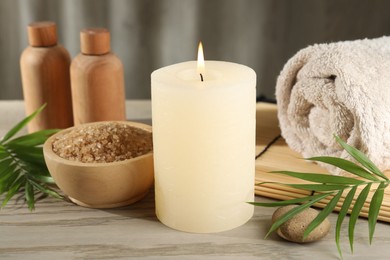 Photo of Spa composition with burning candle on wooden table