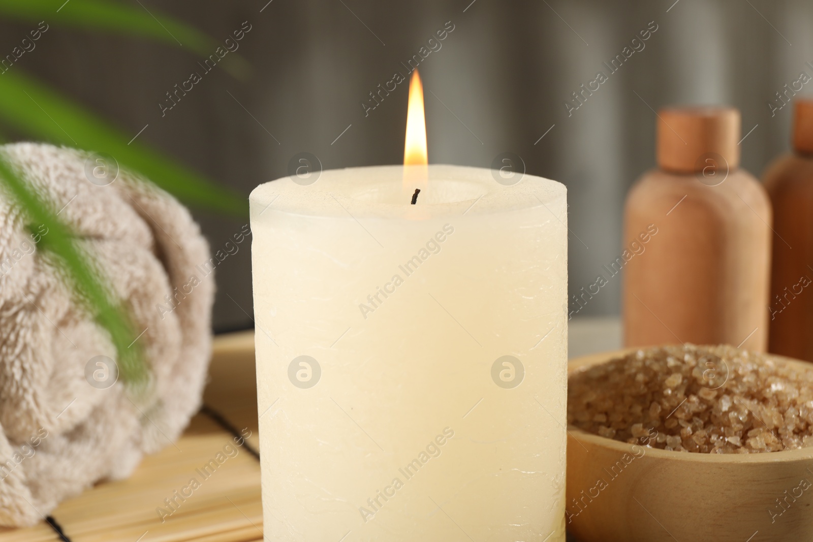 Photo of Spa composition with burning candle on table, closeup