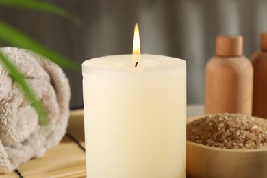 Spa composition with burning candle on table, closeup