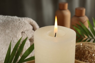 Spa composition with burning candle on table, closeup