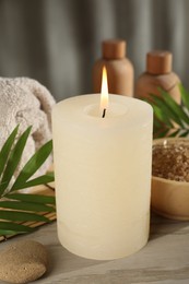 Spa composition with burning candle on wooden table