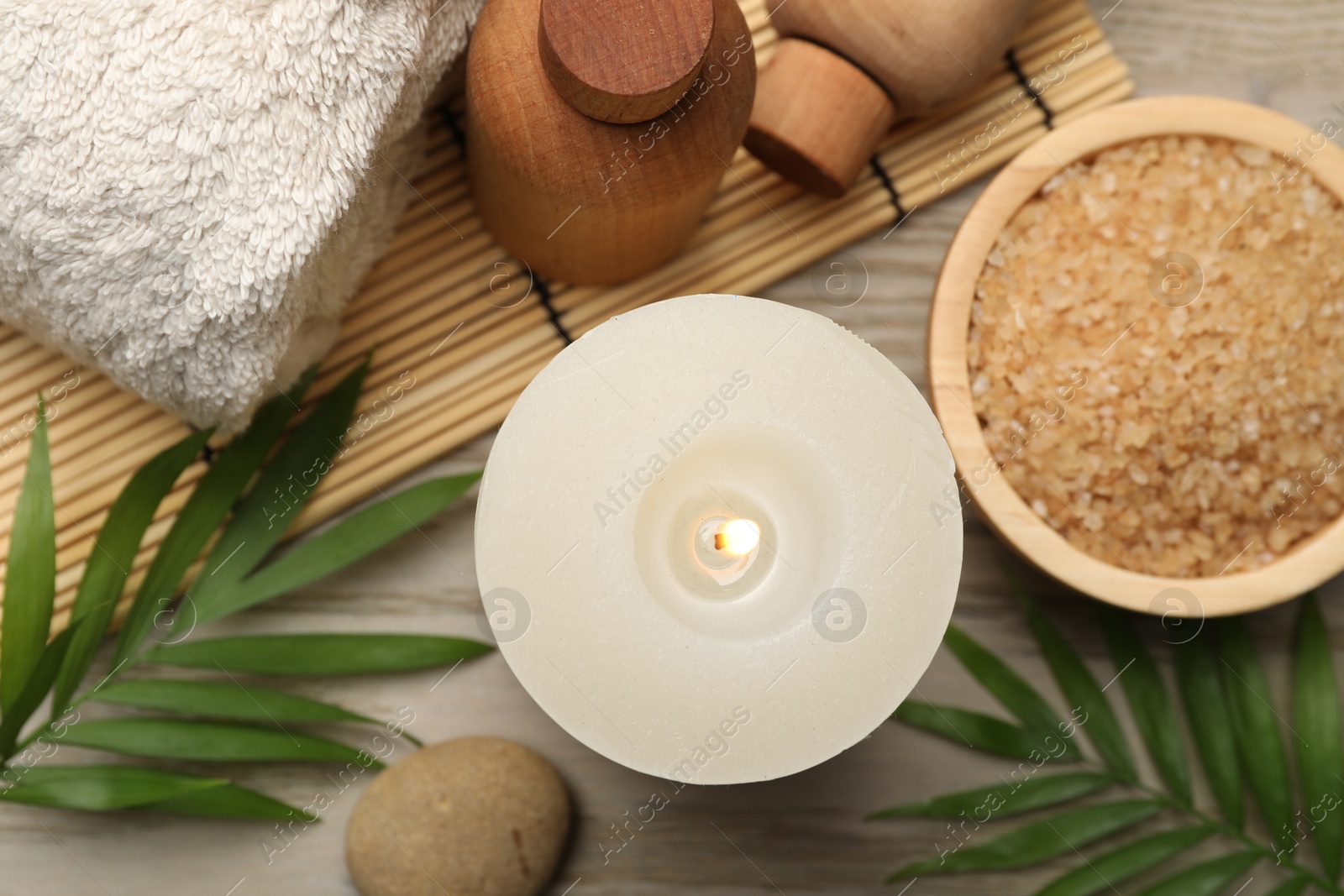 Photo of Spa composition with burning candle on wooden table, flat lay