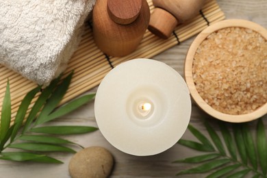 Photo of Spa composition with burning candle on wooden table, flat lay