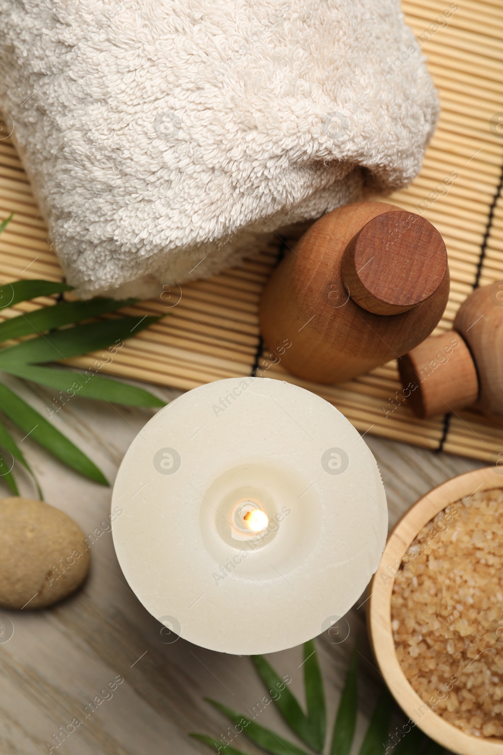 Photo of Spa composition with burning candle on wooden table, flat lay