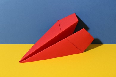 Handmade red paper plane on color background