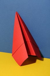 Photo of Handmade red paper plane on color background