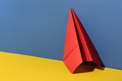 Photo of Handmade red paper plane on color background. Space for text