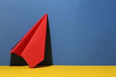 Photo of Handmade red paper plane on color background. Space for text