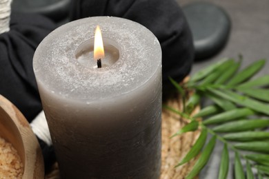 Spa composition with herbal bags and burning candle on grey table, closeup