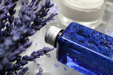 Spa composition with bottle and jar of cosmetic products on grey table, closeup