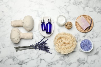 Photo of Spa composition with different cosmetic products, herbal bags and lavender flowers on white marble table, flat lay