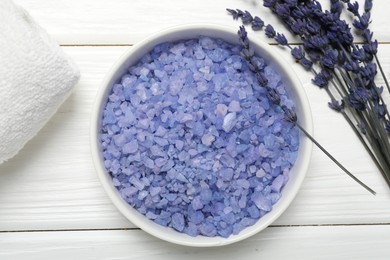 Spa composition with sea salt, towel and lavender flowers on white wooden table, flat lay