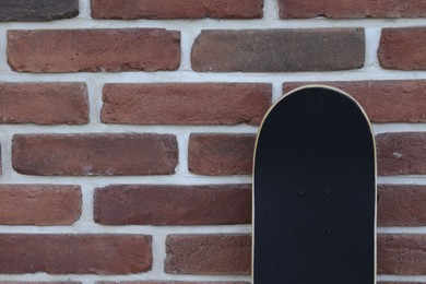 Photo of One skateboard near brick wall outdoors, space for text